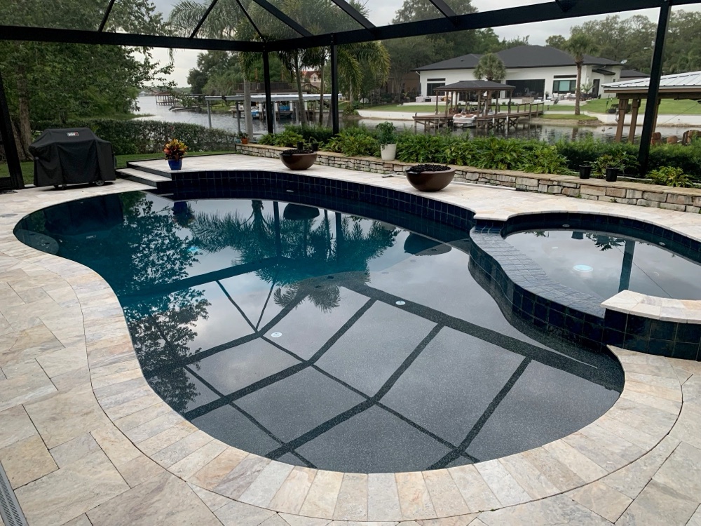 Lakefront resurface + travertine deck + fire bowls — after, view 1