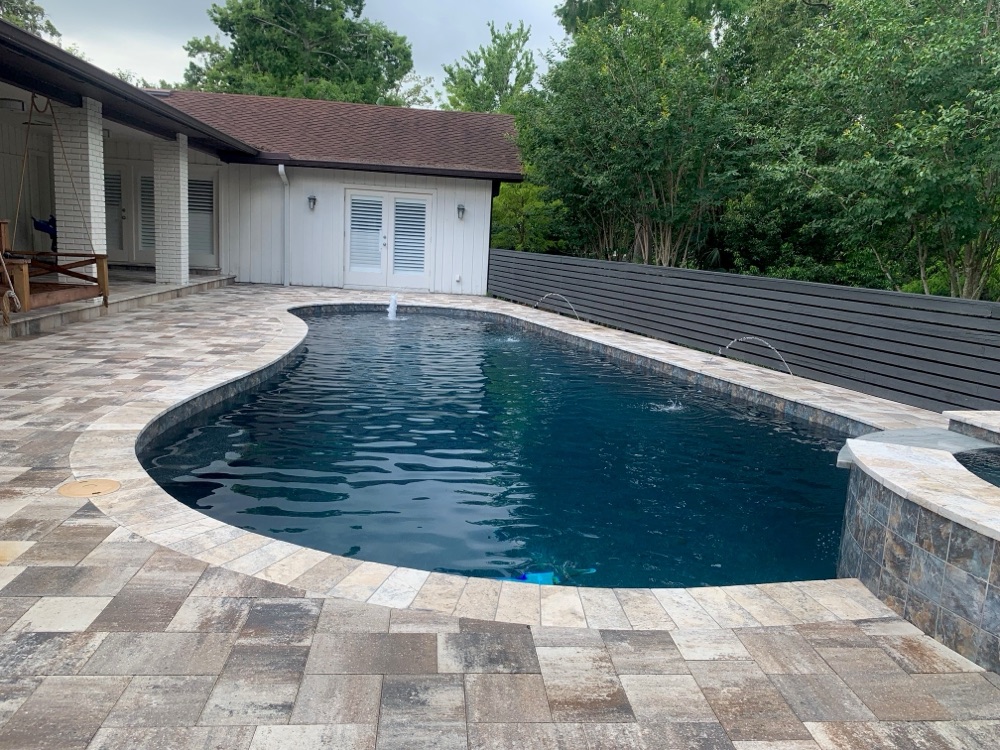 Brick coping to dark resurface + travertine deck — after, view 1