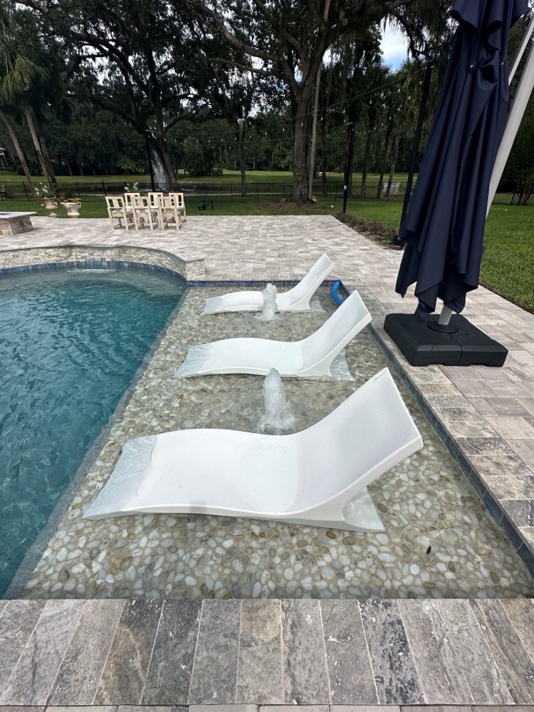 Rock waterfall to pebble sun shelf + loungers — after, view 1