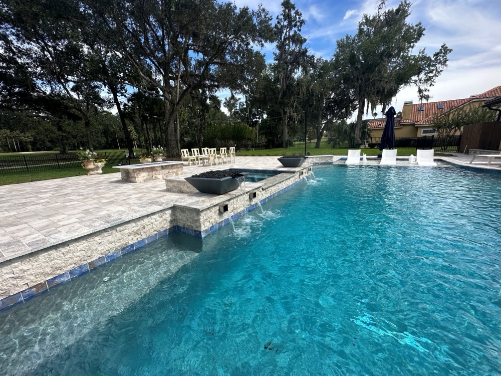 Rock waterfall to pebble sun shelf + loungers — after, view 2